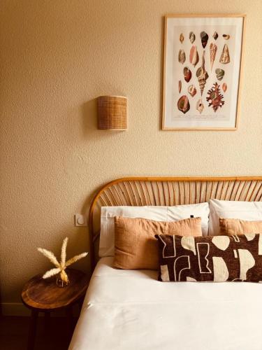 a bedroom with a bed with pillows and a table at Hôtel Le Britannic - centre gare- in Saint Malo