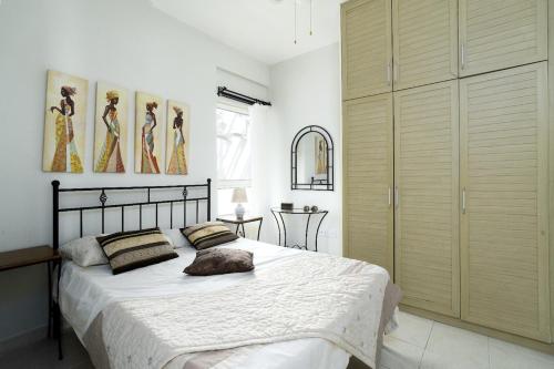 a bedroom with a large bed with white sheets at Turtle Bay Village - Family House in Kérynia