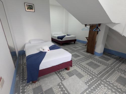 a small room with a bed and a staircase at Hostal Gardner in Puerto Ayora