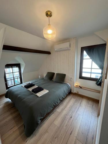 a bedroom with a large bed and a large window at La maison du 122 in Romorantin