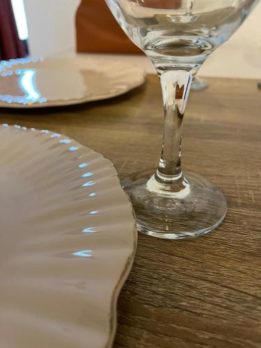 un verre de vin assis à côté d'une assiette sur une table dans l'établissement La maison du 122, à Romorantin-Lanthenay