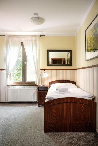 a bedroom with a bed and a mirror and a window at Villa Daniela in Úvaly