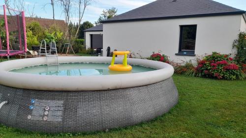 - une petite piscine avec un jouet dans une cour dans l'établissement Logrment entier 8 personnes circuit 24h, à Sillé-le-Philippe