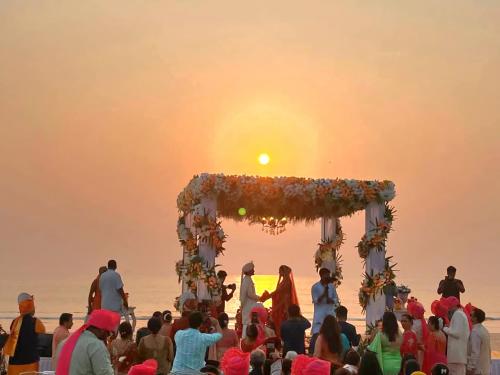 una ceremonia de boda en la playa al atardecer en Samant Beach Villa, en Bhogwe