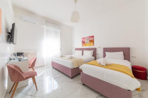 a bedroom with two beds and a chair at Leia Hospitality in Milan