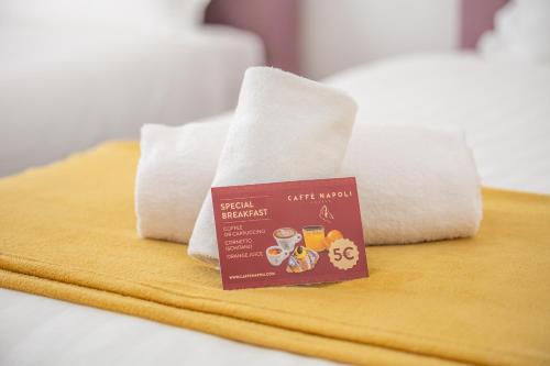 a sign sitting on top of a bed with towels at Leia Hospitality in Milan