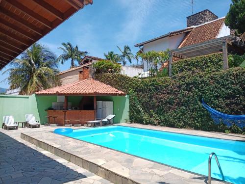 a swimming pool in front of a house at Arrasta Hostel quarto compartilhado in São Sebastião
