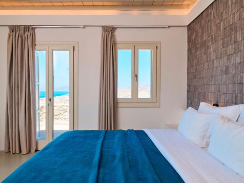 a bedroom with a large bed with a view of the ocean at Mykonos Rocks Villas & Suites in Mýkonos City