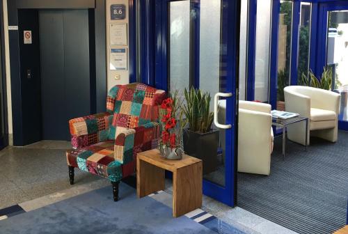 einen Stuhl und einen Tisch in der Lobby in der Unterkunft Ambassador Hotel in Grasbrunn