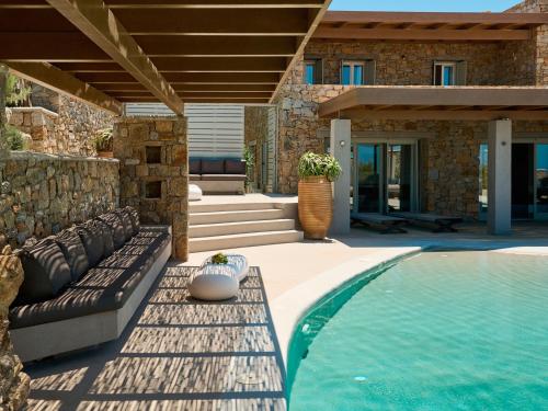 a patio with a couch and a swimming pool at Mykonos Rocks Villas & Suites in Mýkonos City
