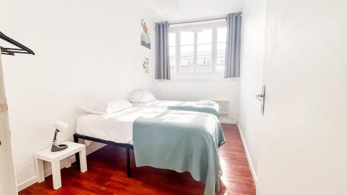 une chambre blanche avec un lit et une fenêtre dans l'établissement Saint François, à Bordeaux