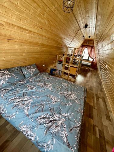 a bedroom with a bed in a wooden wall at Cabana Teo&Matei in Mihăeşti