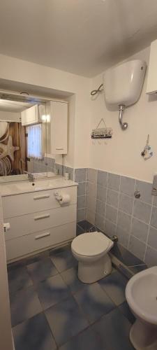 a bathroom with a toilet and a sink at Casa vacanze Pabaule in Gonnesa