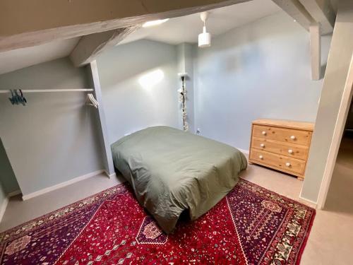- une chambre avec un lit, une commode et un tapis dans l'établissement Appt XVIII centre historique rue du Cloître, à Bordeaux