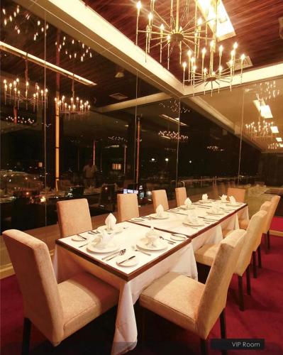 a long table in a restaurant with chairs and tablesearcher at HOTEL HOLITEL PEKANBARU superior double in Pekanbaru