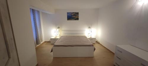a bedroom with a bed in a white room at Casa vacanze Pabaule in Gonnesa