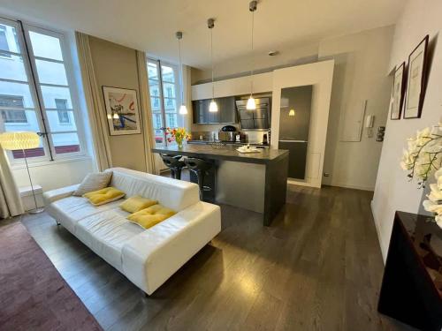 un salon avec un canapé blanc et une cuisine dans l'établissement Magnifique appartement Bordeaux Triangle, à Bordeaux