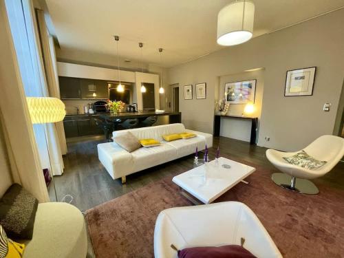 un salon avec un canapé blanc et une table dans l'établissement Magnifique appartement Bordeaux Triangle, à Bordeaux