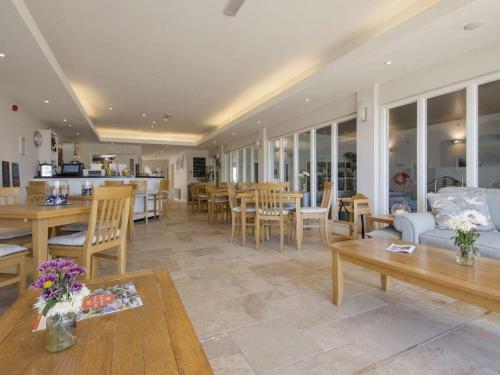 a living room with a couch and tables and chairs at 6 Burgh Island in Kingsbridge