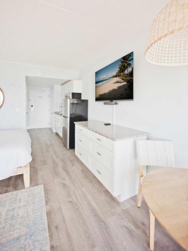 a living room with a kitchen and a dining table at Hampton Tides-Ocean View-Top Floor With Balcony in Hampton