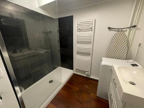 une salle de bain blanche avec une douche et un lavabo dans l'établissement Loft de Charme au Cœur du Centre Historique, à Bordeaux