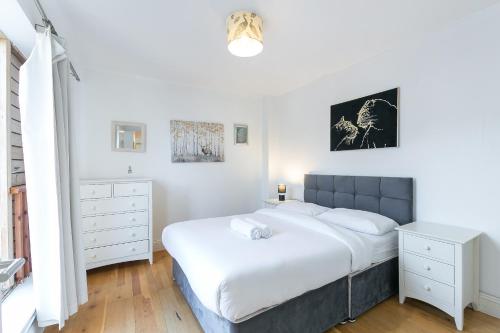 a bedroom with a large bed and white furniture at Flat with London Eye view Big Ben Westminister LM4 in London