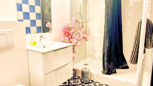 La salle de bains est pourvue d'un lavabo et d'une douche fleurie. dans l'établissement T3 pleincentre airconditionné, à Bordeaux