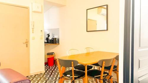 une salle à manger avec une table et des chaises en bois dans l'établissement T3 pleincentre airconditionné, à Bordeaux