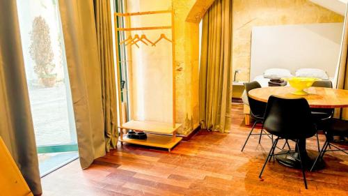 une salle à manger avec une table et des chaises et une fenêtre dans l'établissement Mini Loft 4 P, centre historique, à Bordeaux