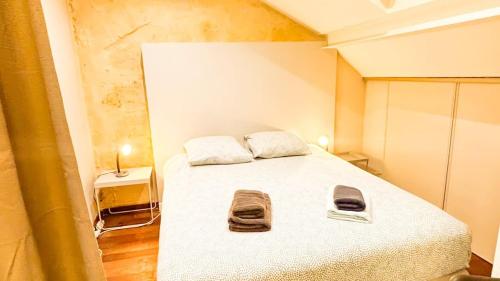 une chambre avec un lit avec deux serviettes dessus dans l'établissement Mini Loft 4 P, centre historique, à Bordeaux