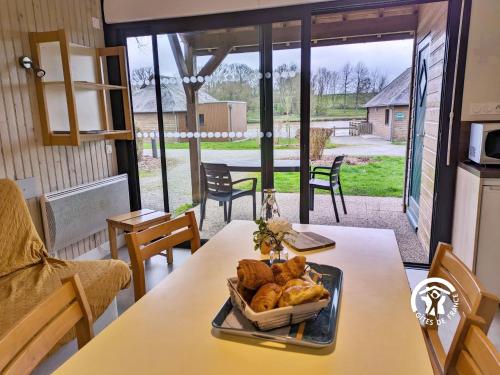 - une table avec un plateau de croissants et de pain dans l'établissement Chalet le Goujon, à Villiers-Charlemagne