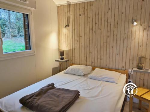 un lit avec deux oreillers dessus dans une chambre dans l'établissement Chalet le Goujon, à Villiers-Charlemagne