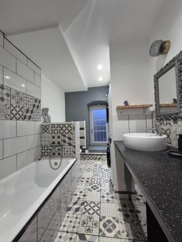 une salle de bain avec une baignoire blanche et un lavabo dans l'établissement #Le Coin Perché #Thiers #Auvergne, à Thiers