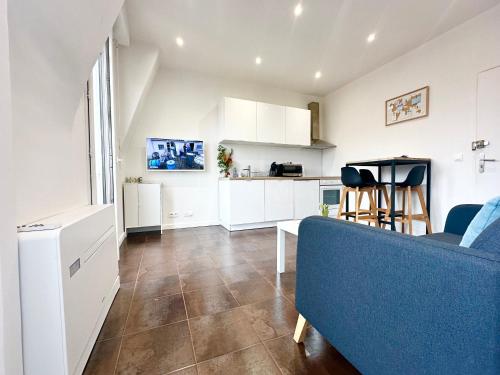 un salon avec un canapé bleu et une cuisine dans l'établissement Beautiful & cosy appart, calme et lumineux, à Nice