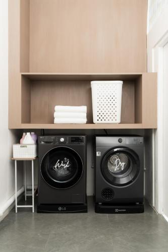 a laundry room with two washing machines under a counter at Sunnyside Kata in Kata Beach