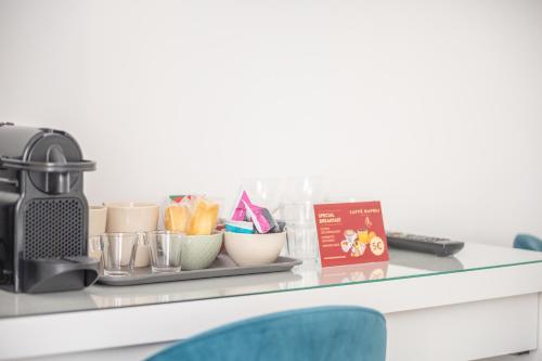 a glass counter with cups and a coffee maker on it at Leia Hospitality in Milan