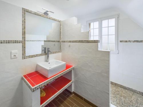 une salle de bain avec un lavabo et un miroir dans l'établissement Authentique maison bretonne pour 6 à Plovan, à Plovan