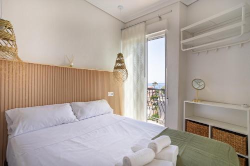 a bedroom with a large white bed and a window at Seaside Serenity in Denia in Denia