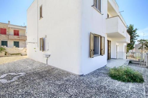 a white house with a courtyard and a building at Casa vacanze torre vado in Marina di Pescoluse