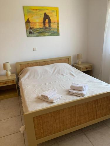 a bedroom with a bed with two towels on it at Sirena Kings in Paphos