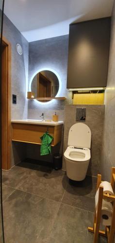 a bathroom with a toilet and a sink with a mirror at OFF Chata na Oślaku, Jacuzzi & Sauna in Jaworzna
