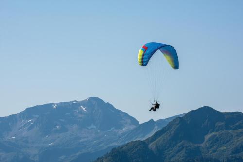 a person para sailing in the air with a parachute at Belambra Clubs Les Saisies - Les Embrunes - Ski pass included in Villard-sur-Doron