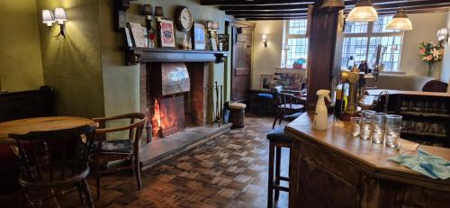 a bar with a fireplace in a pub with a table at The Talbot Hotel in Ledbury