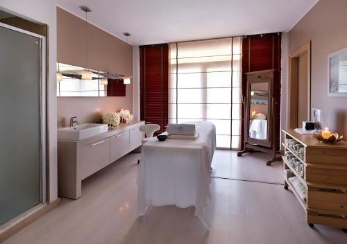 a bathroom with a bed with a laptop on it at Iseo Lago Hotel in Iseo