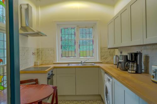 a kitchen with a sink and a window at The Newcastle Residence Cozy & Modern Flats in The Park Estate in Nottingham