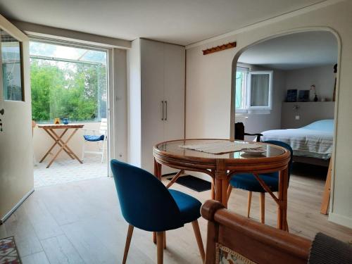 une pièce avec une table et des chaises et une chambre dans l'établissement Giverny, Cosy studio au vert, à Giverny