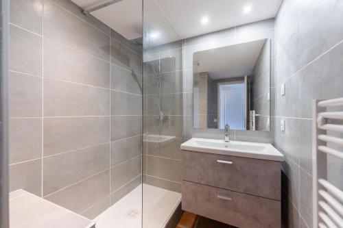 une salle de bain avec une douche, un lavabo et un miroir dans l'établissement Le cabanon d'Olivier, à Le Liouquet