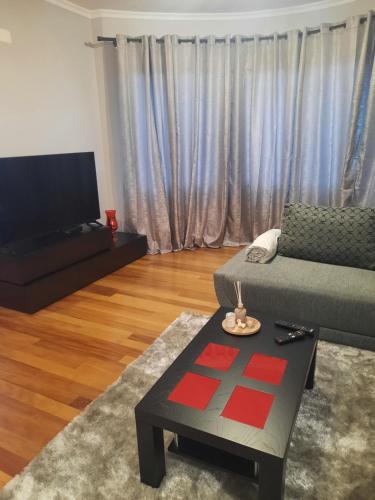 a living room with a couch and a tv at Rose Sun House in Ponta do Sol