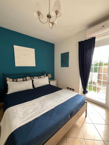 a bedroom with a bed with a blue wall at ValeHouse in Fiumicino