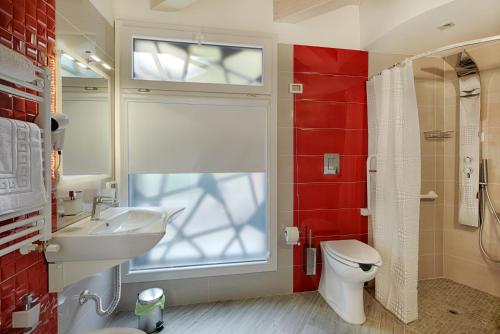 a bathroom with a toilet and a sink and a window at Hospitality Hotel in Palermo